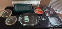 All bakeware and measuring cups arranged on table