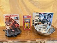 Group shot showing donut maker with box, Hershey’s Kisses cocoa maker box, stainless bowl set box and one bowl