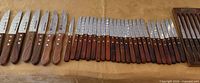 All 38 wooden-handle steak knives lined up