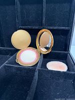 Compact open showing mirror, sifter, puff