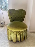 Front view showing heart-shaped tufted back, round seat, and gathered skirt