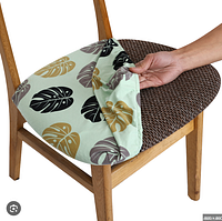 Stretch spandex seat cover partially fitted on wooden chair showing leaf print