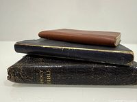 Stack of three religious books showing sizes and colors