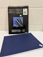 Front and back covers of Studio Art pad with navy pad beside