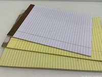 Three writing pads stacked showing colors and bindings