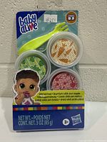 Front of sealed Baby Alive refill pack showing tubs and fork