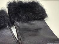 Close-up of glove cuff showing black fur trim and leather texture