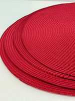 Stacked red round placemats side view
