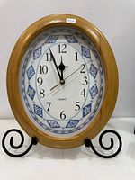 Front view of Bulova oval clock on metal stand