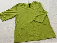 Front view showing lime green tunic with pockets and drawstring