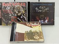 Front view of three CD jewel cases showing album covers: Iron Maiden, Neil Young & Crazy Horse, Led Zeppelin
