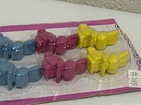 Front of unopened blister pack showing rows of blue, pink and yellow bunny picks