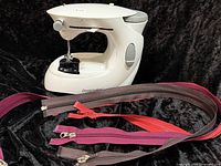 Front view of Dressmaker compact sewing machine with zippers displayed