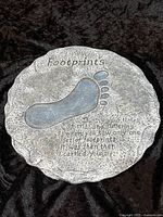 Front view of round Footprints plaque showing footprint design and full inscription