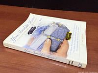 Front angled view of paperback showing spine, front cover and thickness