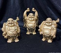 Front view of three gold-tone Happy Buddha figurines