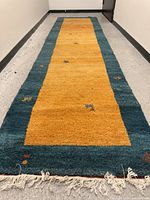 Full view of rug laid out on floor showing colour pattern and fringe