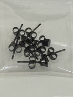 Loose black stud earrings with butterfly backs inside clear pouch
