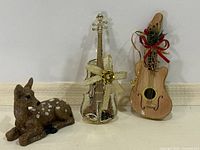 group shot of violin ornament, guitar ornament and fawn figurine