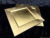 Two gold square charger plates stacked showing overall design