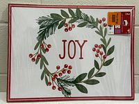 Front view of sealed package showing JOY wreath design