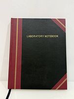 Front cover of hardcover laboratory notebook showing black and burgundy design with gold title