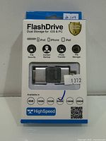 Front of sealed box showing 64GB dual interface flash drive and compatibility icons