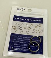 Front view of sealed Fansing Body Jewelry package showing two silver-tone hoops