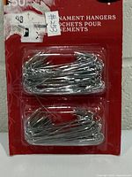 Front of retail package showing two bundles of silver metal hooks and 50-piece count