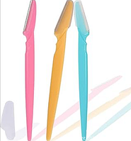 Front view of three colored eyebrow razors standing upright