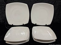 four square dinner plates displayed upright and flat