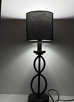 Full view of black metal table lamp showing base, shade, and power cord