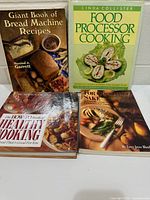 Front covers of all four cookbooks displayed on table