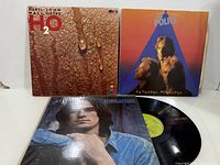 Three album jackets and one vinyl disc displayed