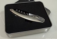 Corkscrew inside foam-lined tin