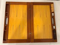 Backgammon board open showing playing surface, checkers, dice and storage compartments