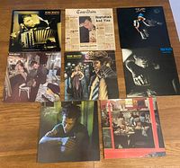 Eight Tom Waits album covers displayed on floor