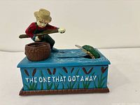 Front view showing fisherman, fish, barrel and base text