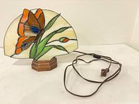 Stained glass fan lamp assembled showing floral panel and wooden base with cord