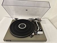 Technics turntable with lid open showing platter and tonearm