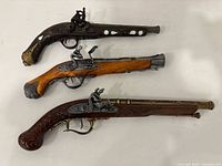 Three replica pistols laid out side by side, showing overall design and length