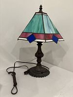 Full view of one lamp showing stained glass shade and cord
