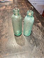 Two aqua glass bottles on tabletop