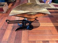 Side view of scale showing cast iron base, beam, sliding weight and brass pan