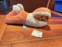 Plush pajama bag doll lying on floor showing orange and white body and vinyl face