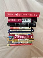 Stack of 11 antiques reference books showing spines