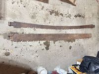Both crosscut saw blades laying side by side on floor