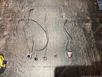 Overview of five cord necklaces laid out on table