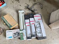 Group shot showing all boxed items and loose faucet on concrete floor