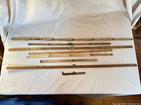 all eight wooden ruler sections laid out extended on cloth